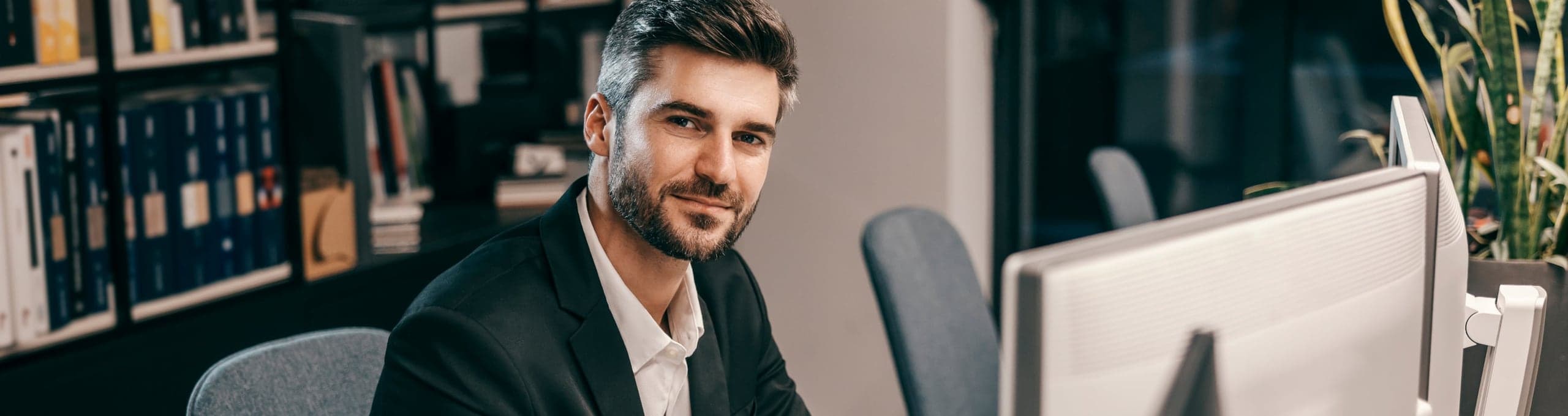 Poslovni čovjek za monitorom u kancelariji